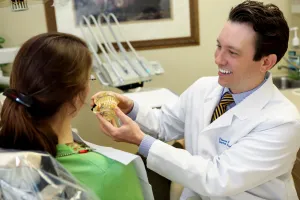 Doctor Sierakowski showing patient model of teeth